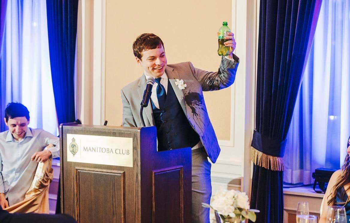 Josh toasting with a ginger ale while covered in ginger ale