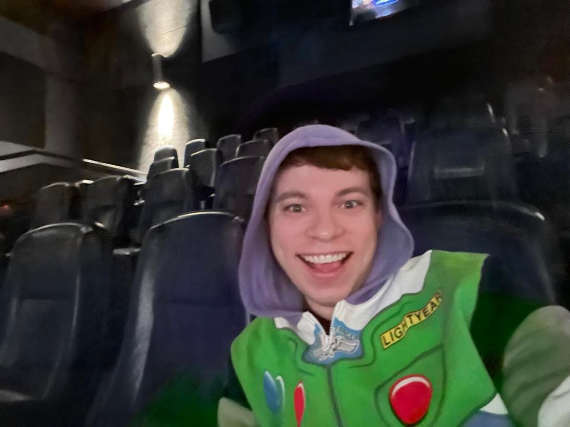 Josh alone in a movie theatre wearing a Buzz Lightyear hoodie