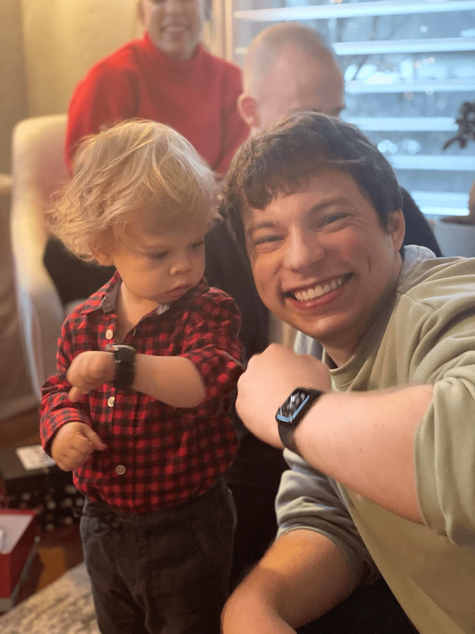 A toddler eyeing his uncle's cool watch