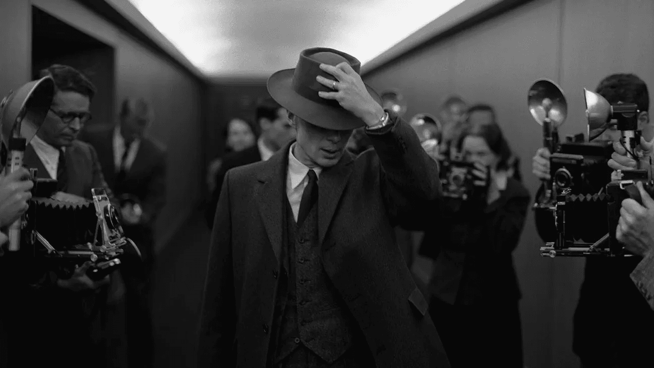 Black and white photo of Oppenheimer avoiding the press from the movie Oppenheimer