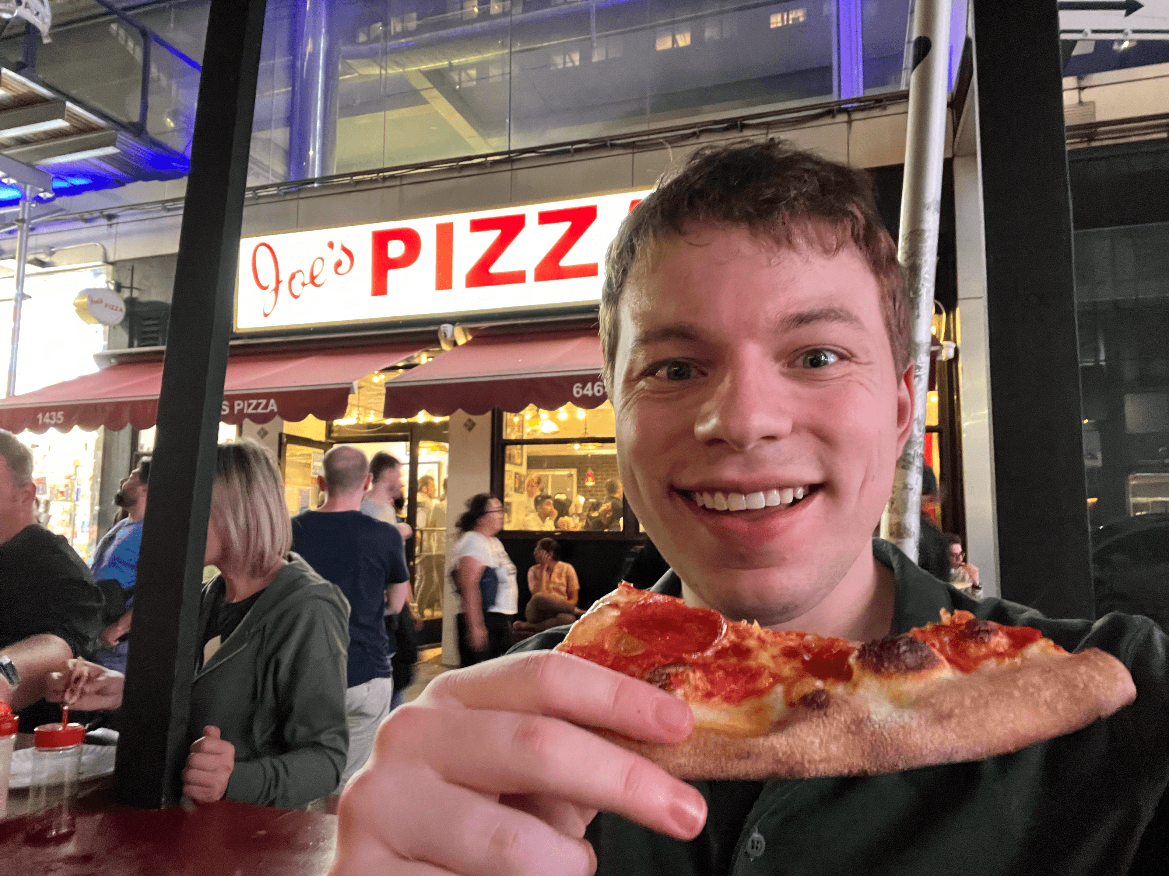 Josh enjoying a slice of Joe's Pizza